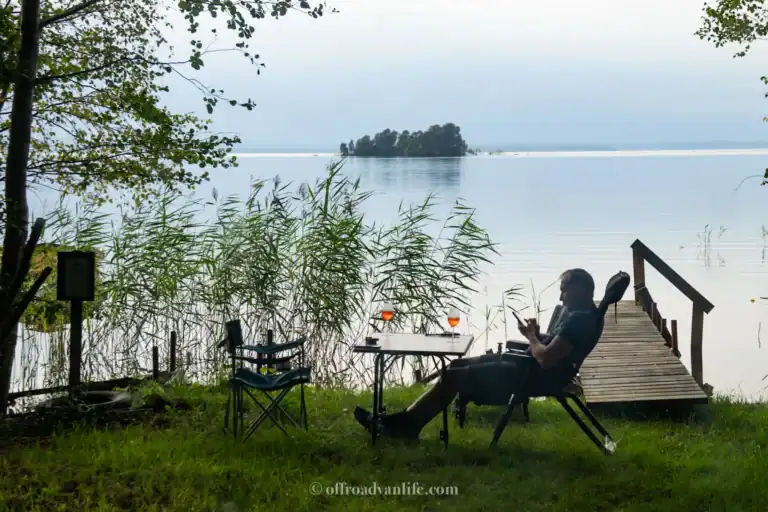 A man sitting in a camping chair lwith the lake view in Sweden