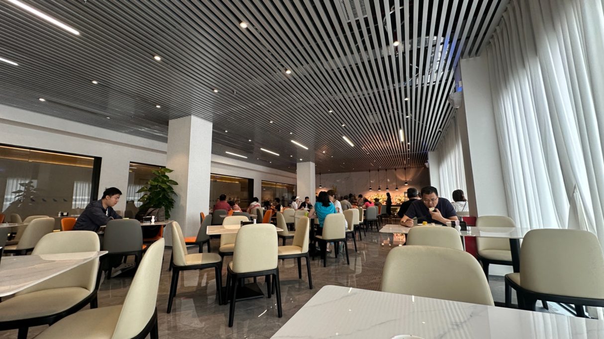 Ein modernes Restaurant mit Gästen an Tischen und hellem, einladendem Ambiente.