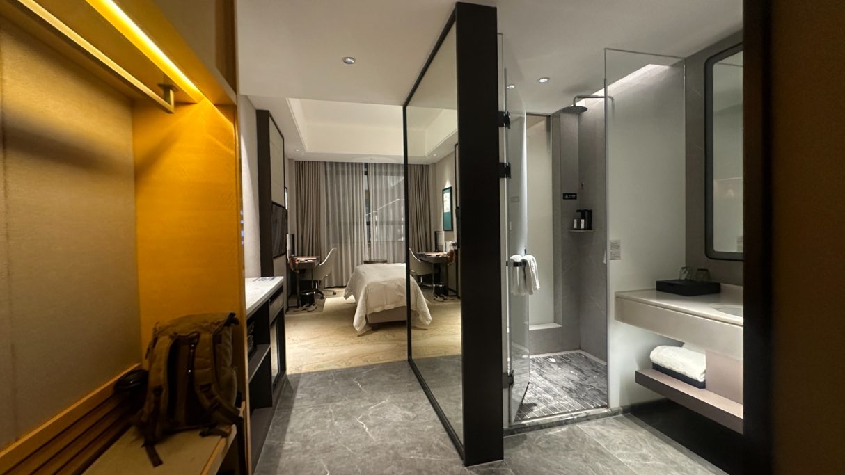 Modernes Hotelzimmer mit offener Dusche und minimalistischer Einrichtung.